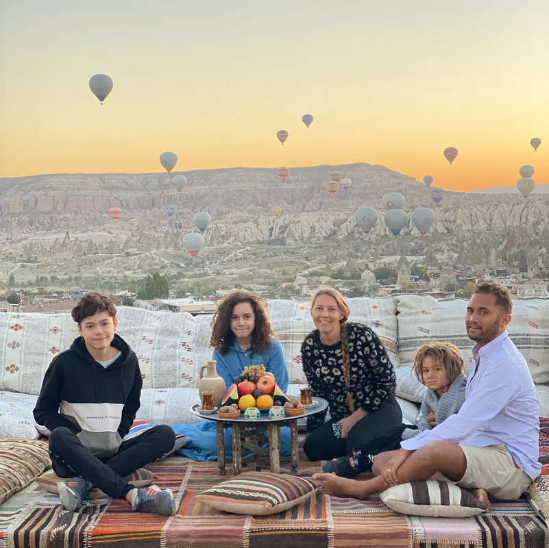 Family watching hot air balloons at sunrise in Cappadocia, Turkey - World Travel Ambitions