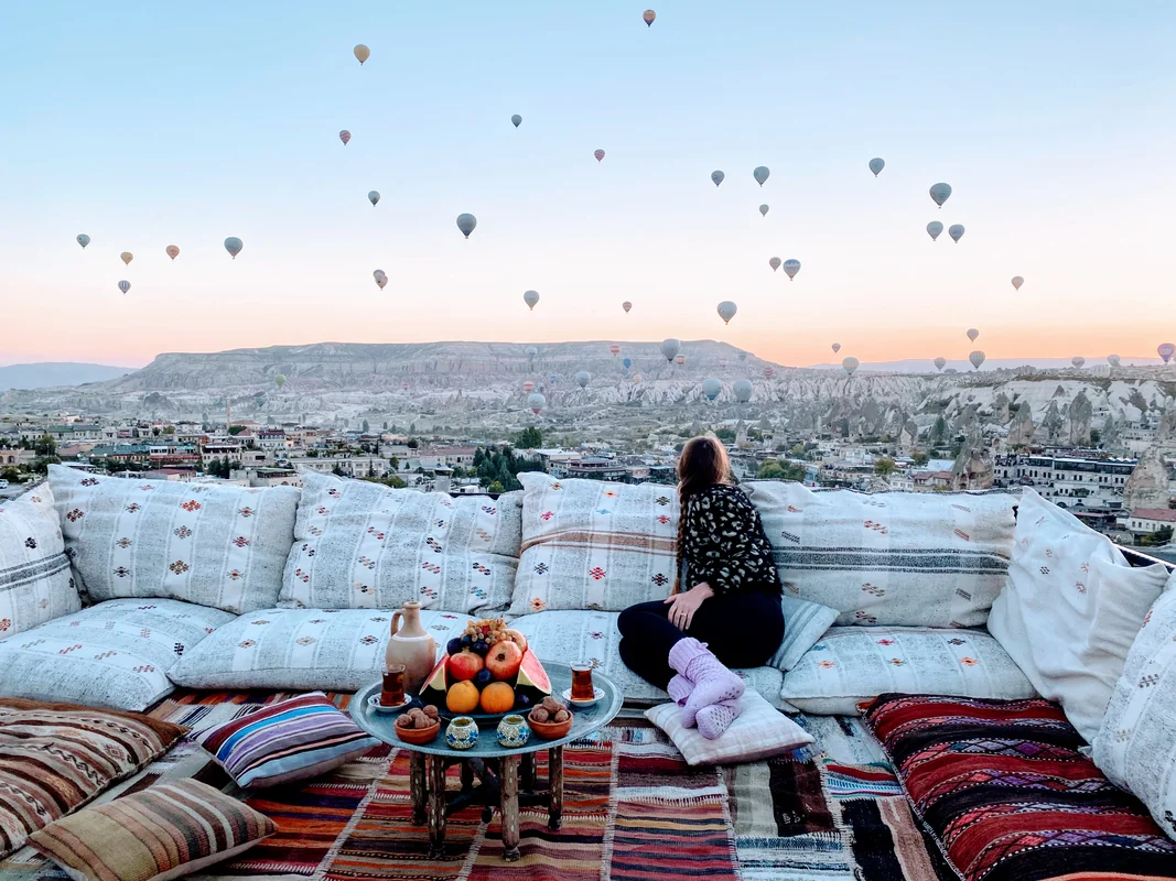 Melissa enjoying breakfast while watching hot air balloons at sunrise in Cappadocia, Turkey - World Travel Ambitions
