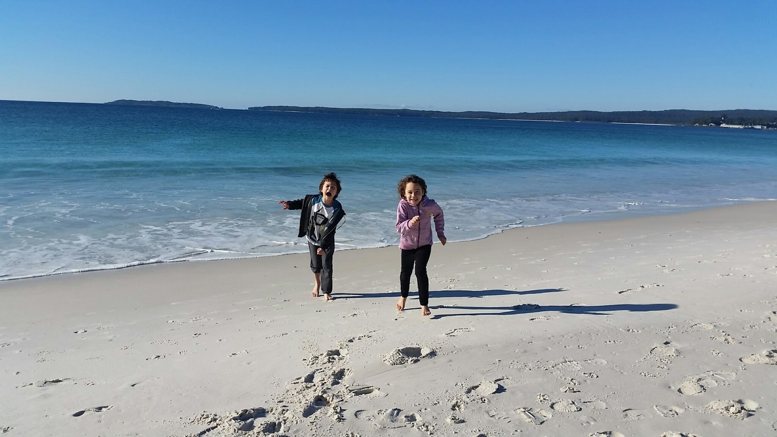 Two children running on the whitest sand at Hyams Beach, Jervis Bay, NSW