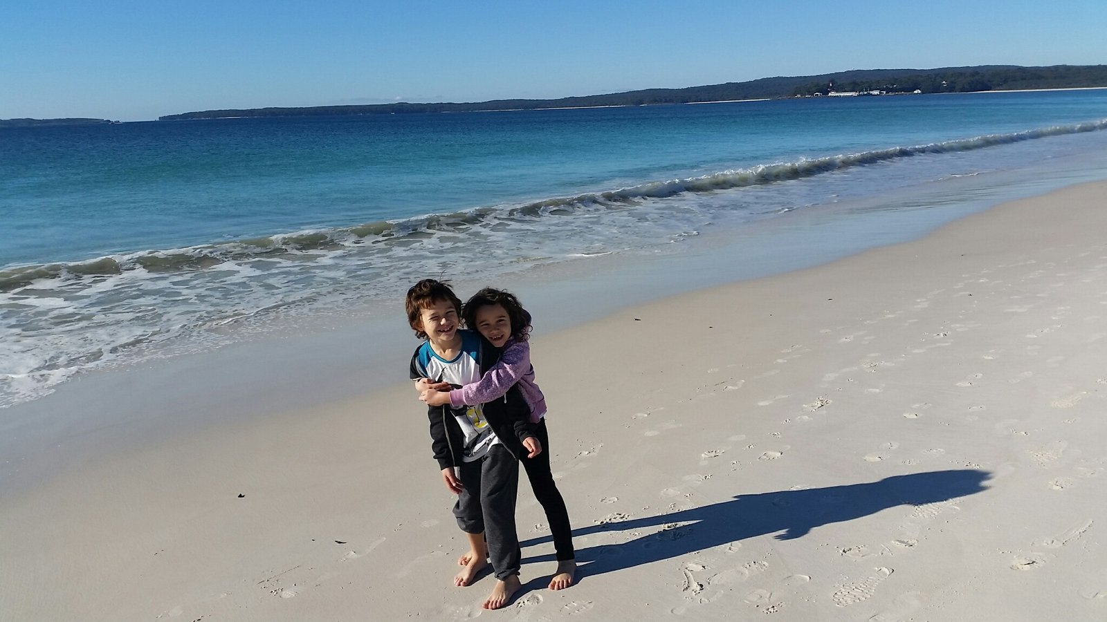 Two children standing on the whitest sand at Hyams Beach, Jervis Bay, NSW