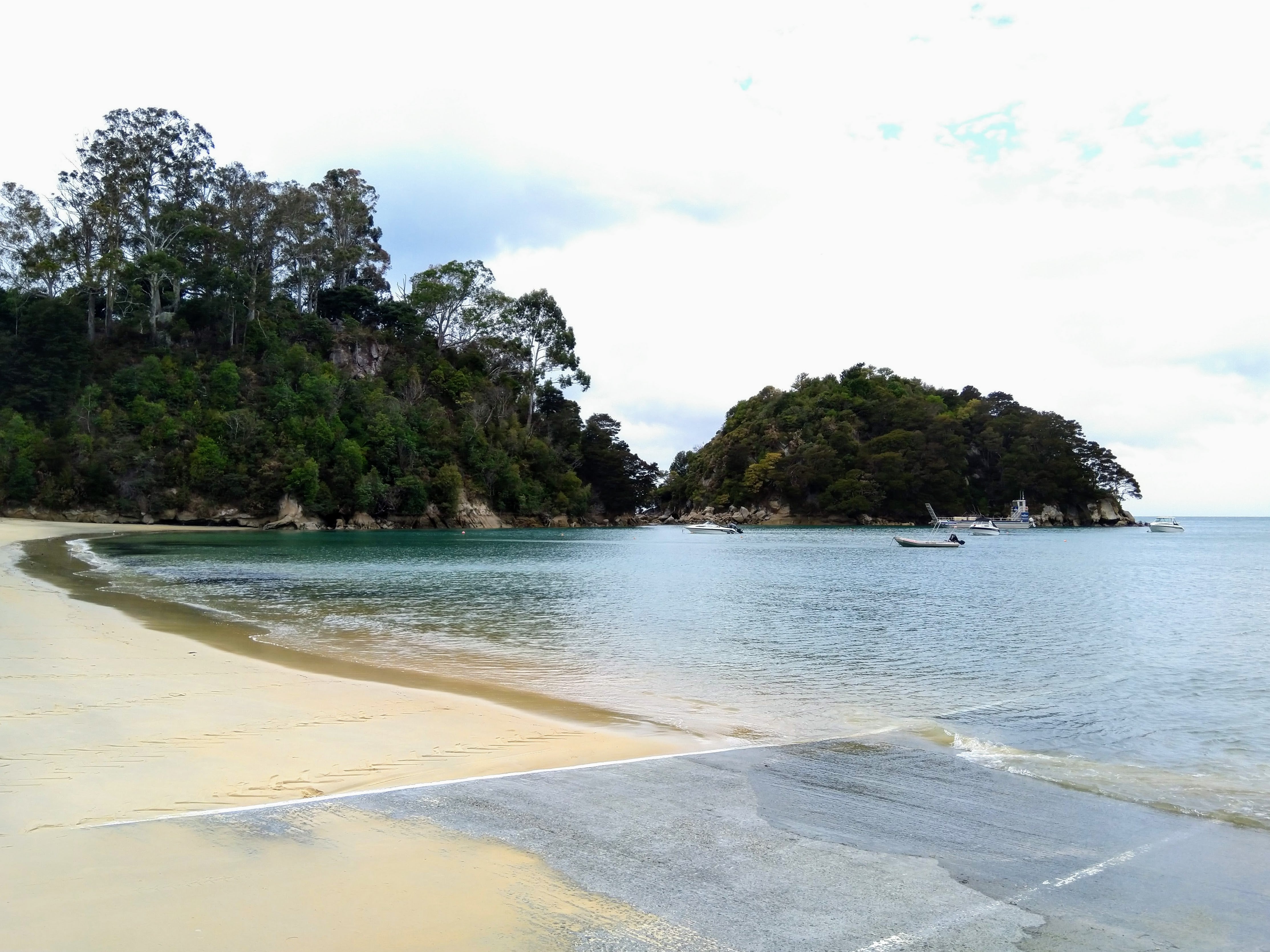 Beautiful Kaiteriteri bay with turquoise waters, sandy beach, and lush green islands in New Zealand