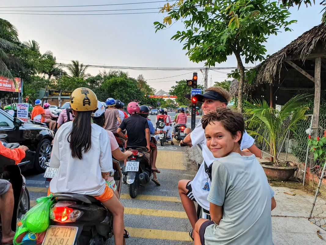 Vietnam family travel - kids riding ebike in An Bang Beach, Vietnam transportation tips
