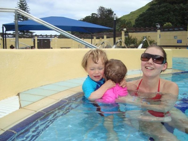 Family enjoying the natural hot pools at Mount Maunganui with scenic mountain backdrop