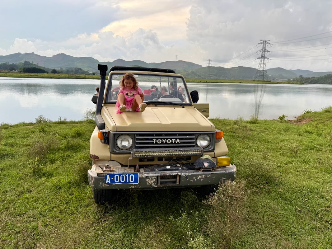 Sunset Safari Jeep Phong Nha Farmstay Vietnam - Young child on vintage Toyota Land Cruiser jeep during sunset safari tour - World Travel Ambitions