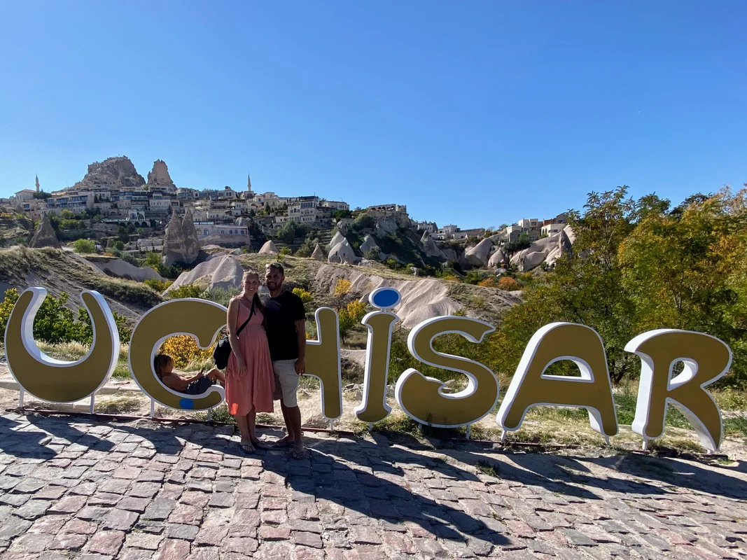 Family at Uchisar sign in Cappadocia, Turkey - World Travel Ambitions